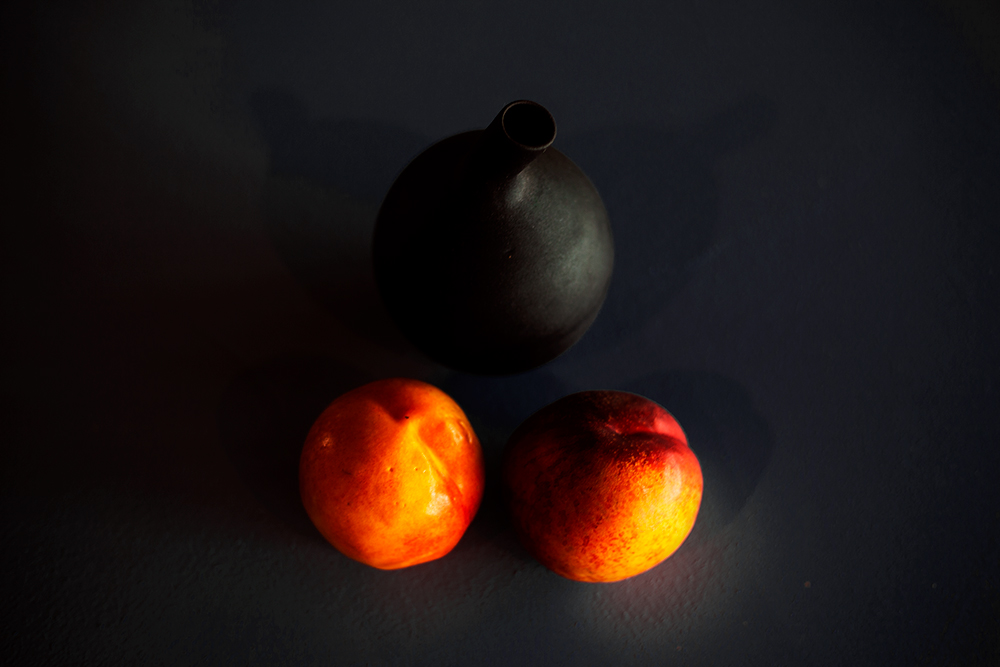 Two Peaches and a black Pot